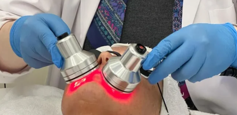 Dermatology professional performing a device-based skin treatment.