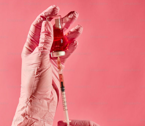 Gloved hand preparing a syringe of hyaluronic acid filler
