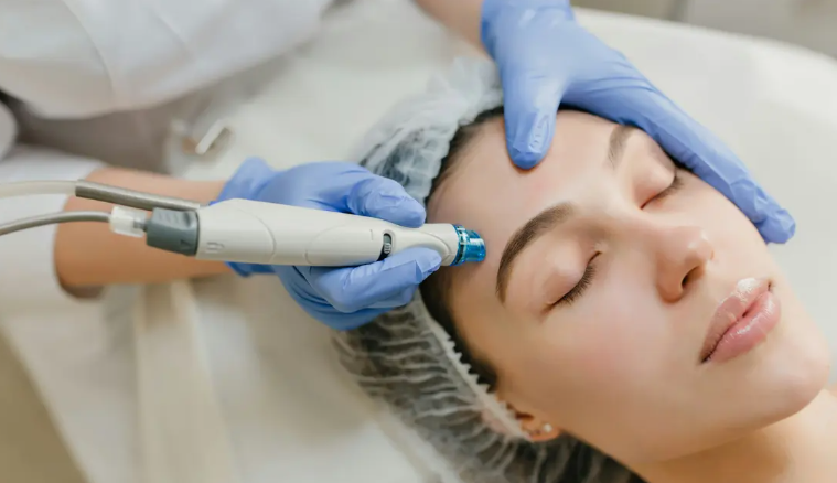 Aesthetic medical assistant performing a facial device treatment on a patient in a clinic