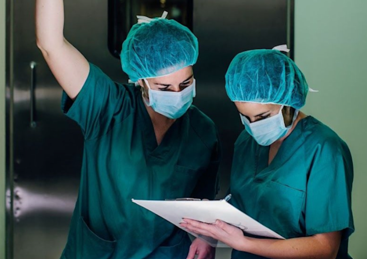 Two plastic surgery team members in scrubs reviewing patient documentation.