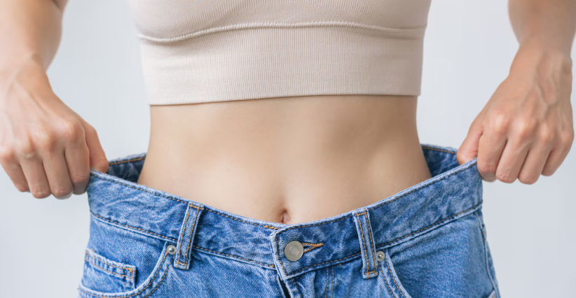 Person holding out loose jeans after major weight loss