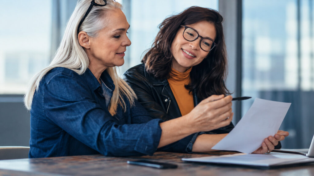 Two colleagues reviewing a document together at a desk