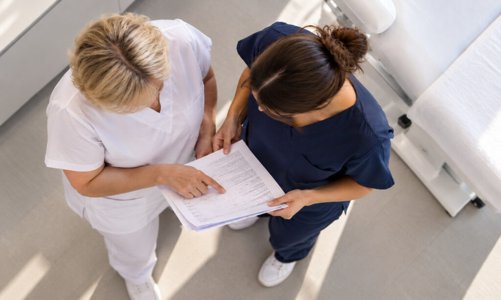 Two clinicians reviewing a document together, seen from above
